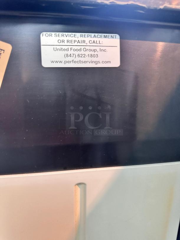 True GDM-23-HC-TSL01 merchandiser refrigerator in outstanding condition. Features single glass door, fully tested, 115V. United Food Group service label shown.