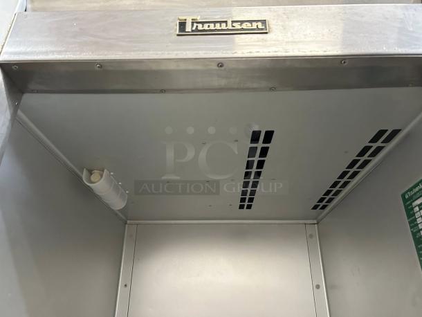 Traulsen G10010 stainless steel reach-in refrigerator interior, visible Traulsen logo, vents, and green instruction label.
