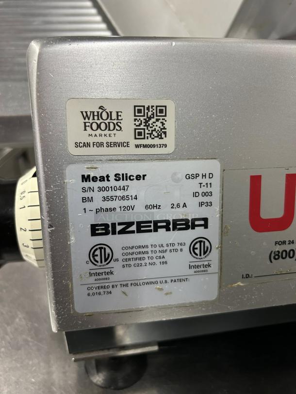 Bizerba GSP HD meat slicer label showing specs: 120V, 60Hz, 2.6A, IP33, ETL certified. Whole Foods QR code for service.