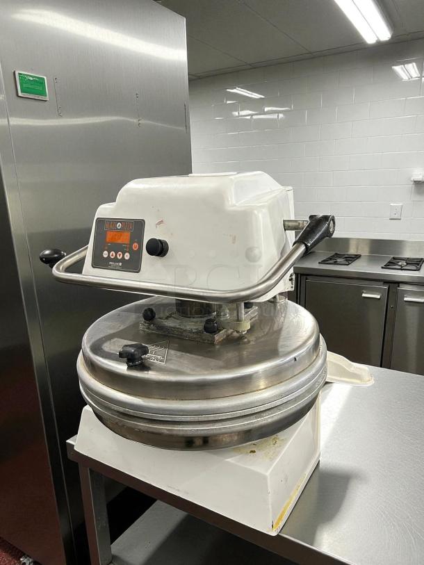 Proluxe Endurance DP2010SE 12" dual-heat dough press in working condition on a stainless steel table.