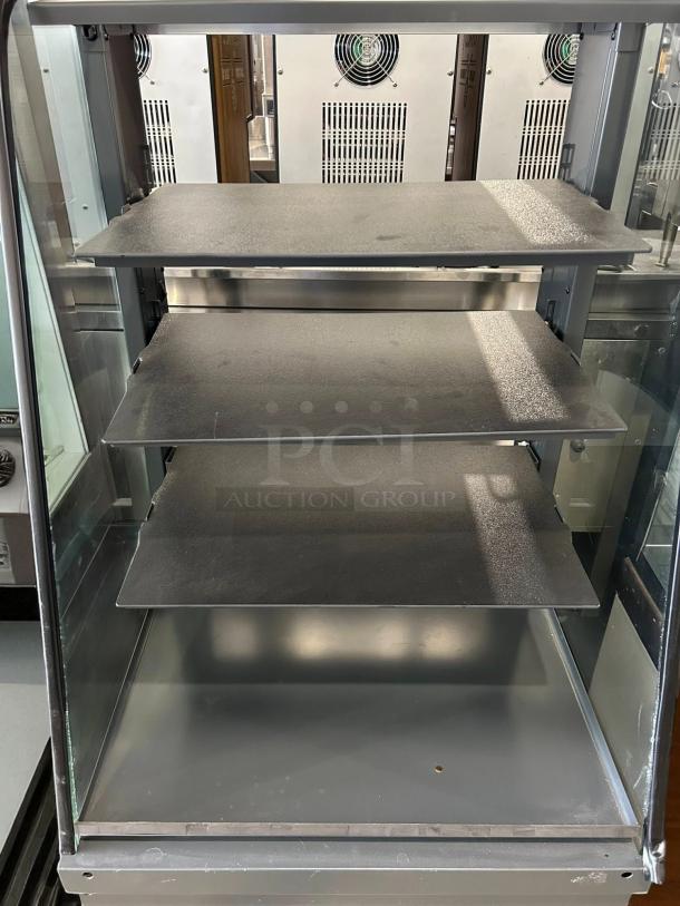 Curved glass refrigerated display case with four adjustable shelves, excellent condition, tested and working.