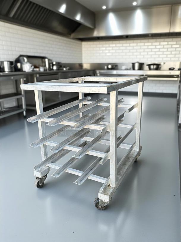 Heavy-duty six-tier aluminum bun/sheet pan rack on wheels in outstanding condition, ideal for commercial bakery use.