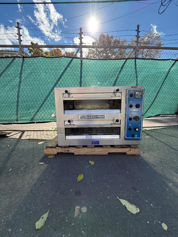 Bakers Pride EP-2-2828 double deck electric pizza oven on pallet, stainless steel, visible control panel, outdoor setting.