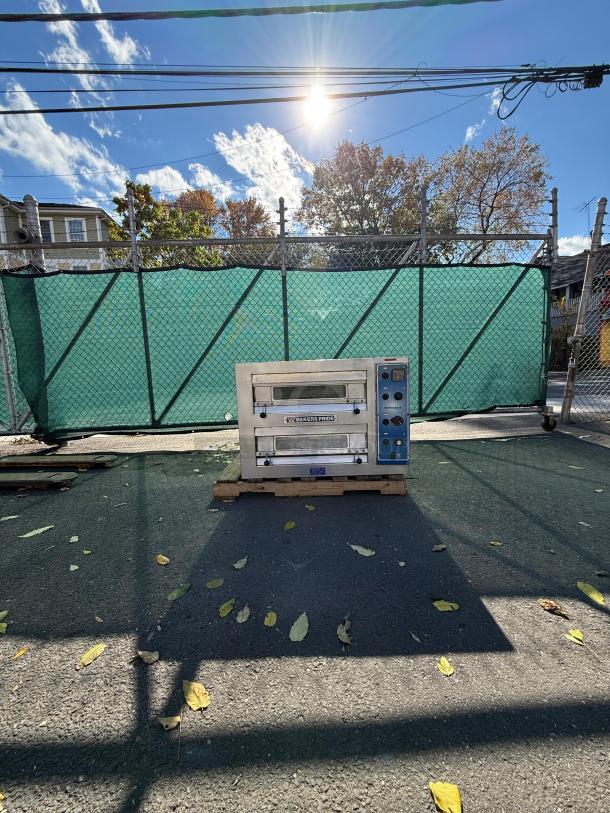 Bakers Pride EP-2-2828 double deck countertop electric pizza oven on pallet, exterior setting, visible logo and control panel.