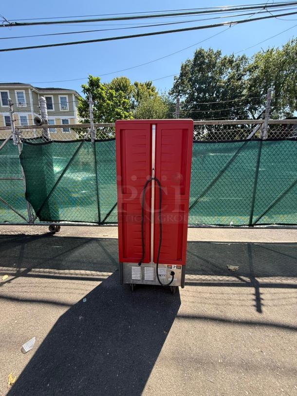 METRO C539-HDS-U heated holding cabinet with red solid Dutch doors, shown outdoors.
