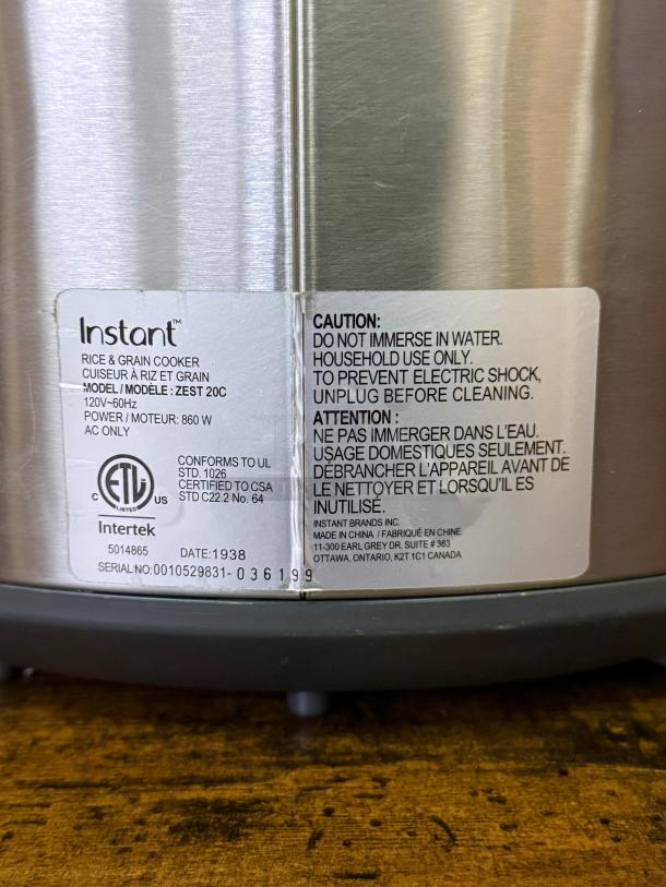 INSTANT POT Zest Plus 20-Cup Rice and Grain Cooker, stainless steel. Model ZEST 20C, 860W. Features caution and certification labels.