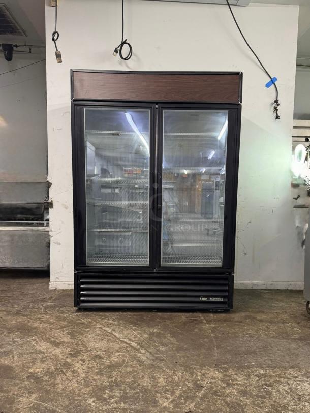 TRUE GDM-49-HC~TSL01 glass door merchandiser, 2 left hinge doors, black, used, 115v, spacious interior, branded base.