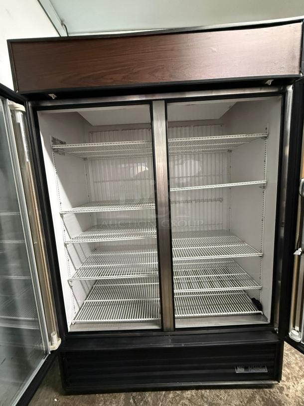 TRUE GDM-49-HC~TSL01 glass door merchandiser, black, two-section, left hinge doors, 115v, good condition, shelves visible.