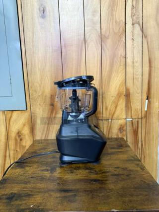 Ninja Mega Kitchen System BL 770, 1500W blender; black base, clear pitcher, good condition, wood background.