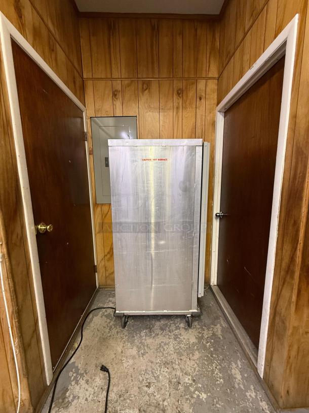 Full-size insulated proofer/warming cabinet, metal finish, on wheels, labeled "Caution: Hot Surface," in good condition.