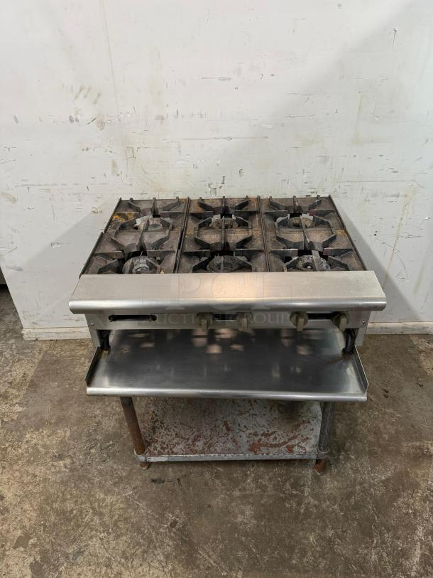 AMERICAN RANGE 36" commercial 6 burner range, model in used condition. Features durable stainless steel body, gas knobs, and open shelf.