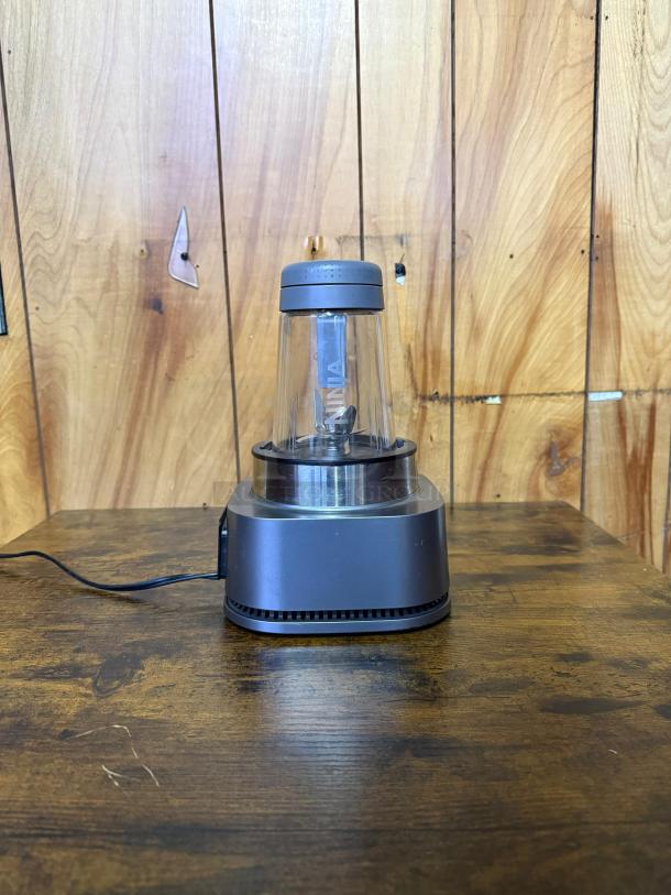 Ninja SS101 blender for kitchen, featuring a 1200 peak watt motor, clear container, and gray base. Ideal for smoothies and sauces.