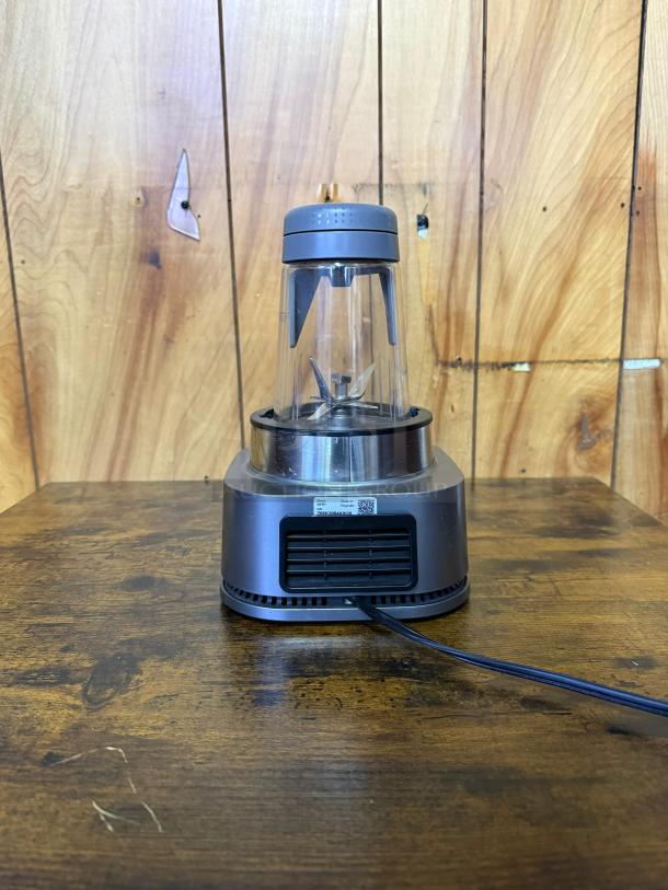 Ninja SS101 blender with 1200-watt motor, clear blending jar, gray lid, on wood surface. Ideal for smoothies, sauces.