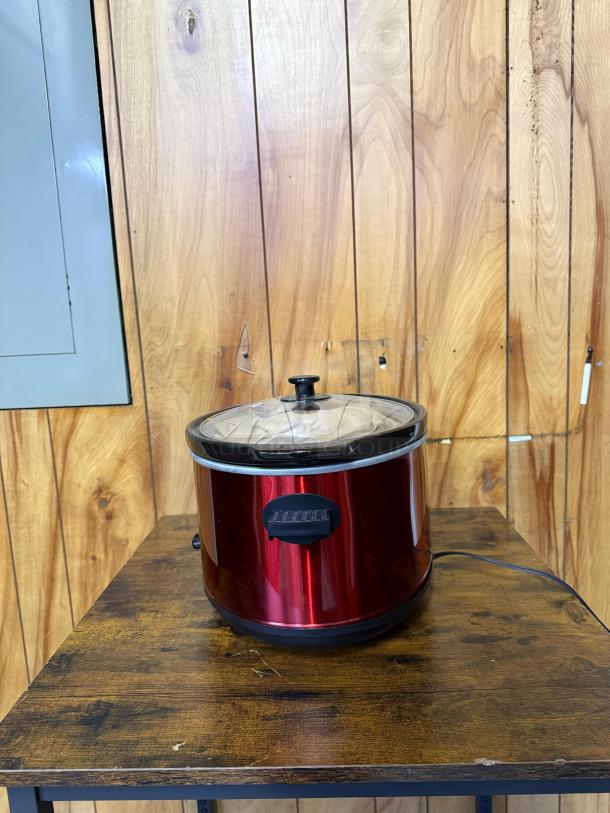 Elite Gourmet 8.5-qt stainless steel slow cooker, red, glass lid, model 8.5 QT, used condition, on wooden table.