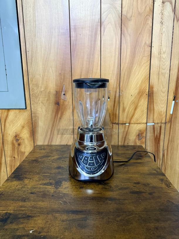 Oster Pro 500 Blender with glass jar and brushed nickel finish. Features multiple control buttons. Appears in good condition.