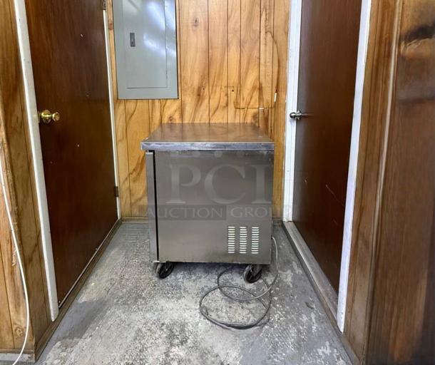 Arctic Air MCF-27U 27" undercounter freezer; stainless steel, on casters, in used condition, visible power cord.