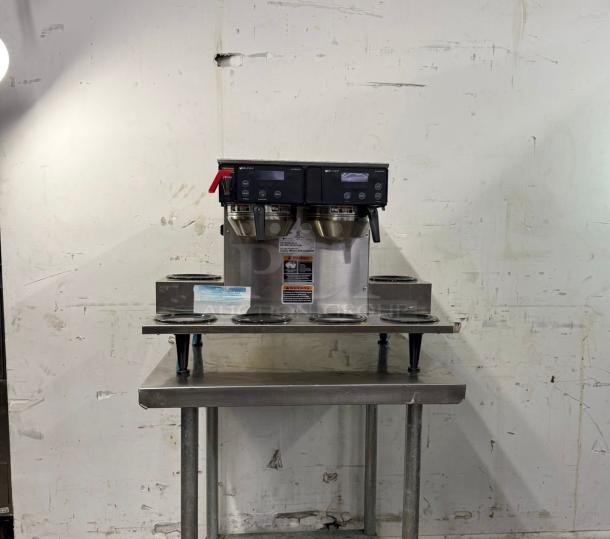 Brand new BUNN Axiom 0/6 Twin 12 Cup Automatic Coffee Brewer. Features 6 lower warmers, stainless steel build, and control panel.