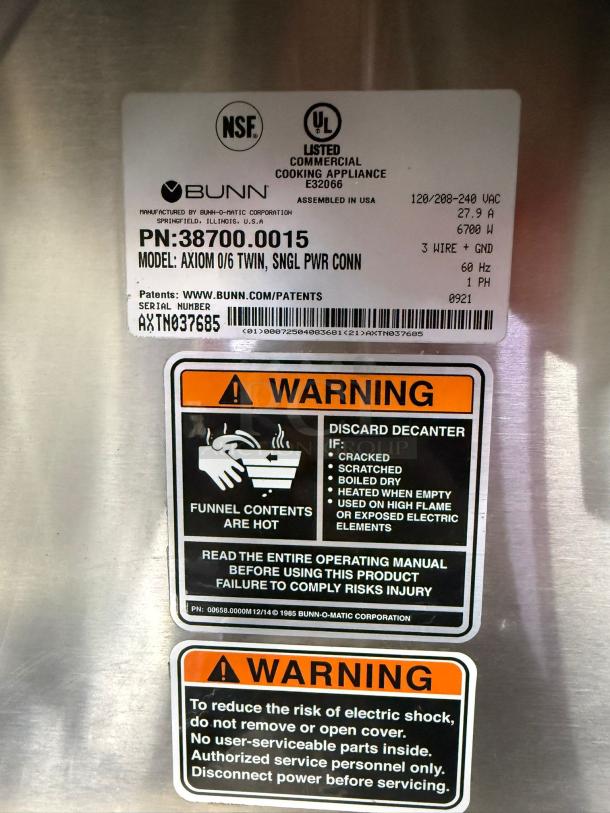 BRAND NEW Bunn Axiom 0/6 Twin 12 Cup Coffee Brewer, 6 Lower Warmers, Model 38700.0015, NSF/UL listed, warning labels visible.