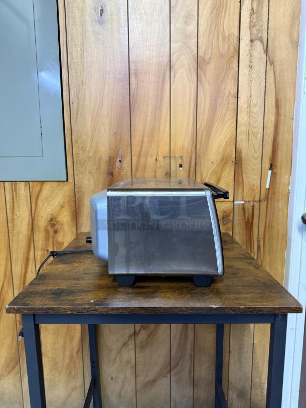 Hamilton Beach 4-slice toaster oven, stainless steel, features 5 cooking modes and 2 rack positions, shown in side view.