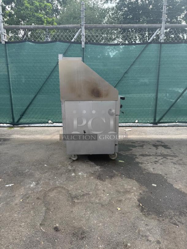 Vulcan 36S-6BN gas range with 6 burners, 36" width, and standard oven. Heavy-duty, outdoor setting, some wear visible.