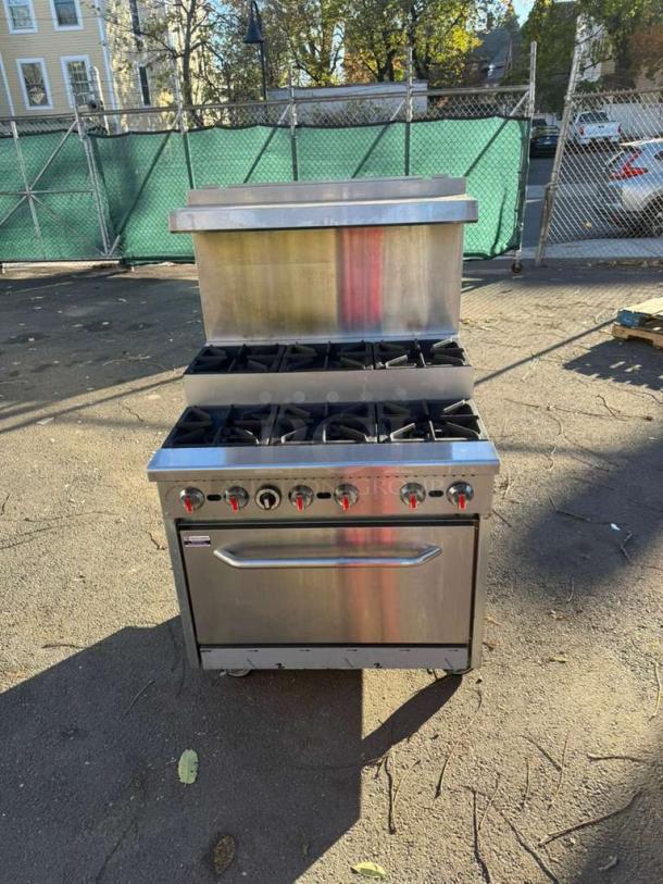 Pro Series 36" Gas 6 Burner Step-Up Range with standard oven, overshelf, and control knobs. Exterior shows minor wear.