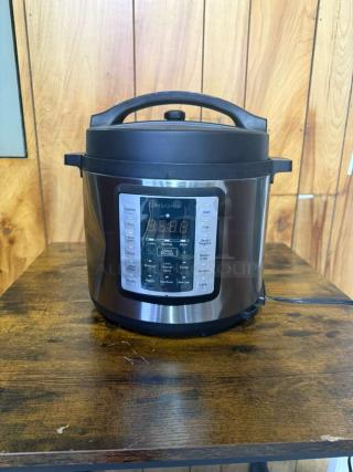 Insignia™ 6-Quart Stainless Steel Pressure Cooker, model MC60SSG, features a digital control panel with multiple settings.