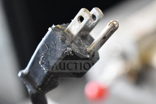 Close-up of a slightly worn three-prong power plug, likely from the 2021 Henny Penny 600 pressure fryer.