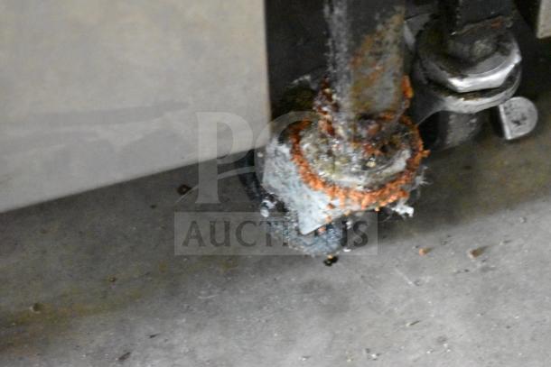 2021 Henny Penny 600 fryer caster showing visible rust and wear, part of a natural gas-powered pressure fryer unit.