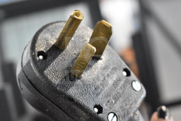 Close-up of the plug for a Thermoplan Mastrena M2-CS espresso machine, showing the prongs and voltage label.