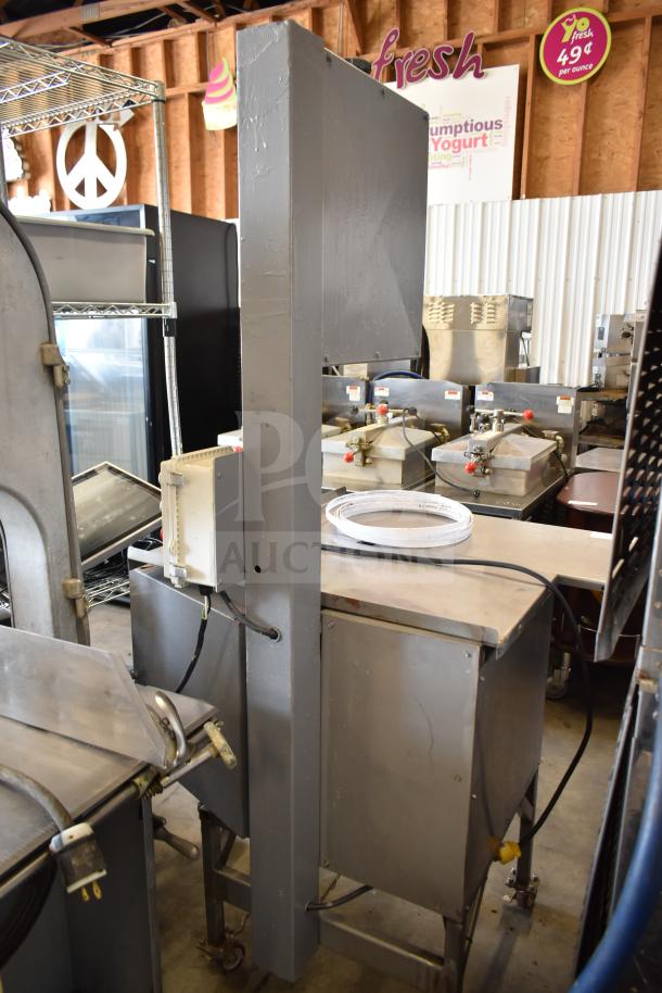 Commercial floor-style meat saw on casters, metal construction, includes power cable, condition appears used, ideal for industrial use.