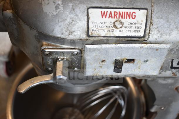 Hobart A-200 commercial dough mixer with 20-quart bowl, dough hook, and whisk. Used condition, visible wear on metal. Model label present.