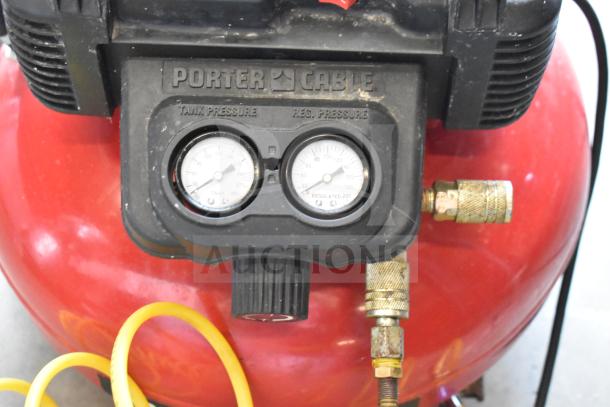 Porter & Cable C2002 air compressor, 120V, 1 phase, red tank, dual pressure gauges, brass fittings, visible wear.