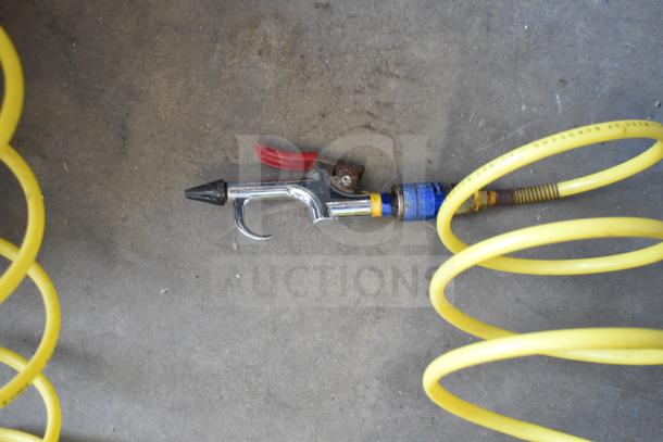 Porter & Cable C2002 air compressor hose and nozzle, shown on concrete. Bright yellow coiled hose, in used condition.