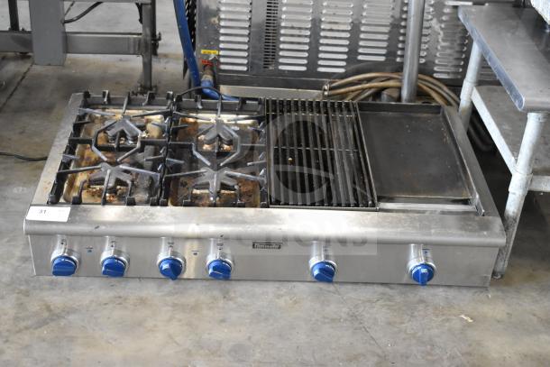 Thermador commercial 4-burner gas range with charbroiler and flat top griddle. Used condition, stainless steel, blue knob controls.