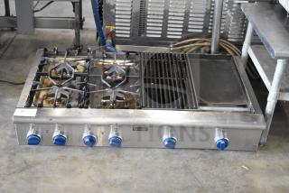 Thermador commercial 4-burner gas range with charbroiler and flat top griddle. Used condition, stainless steel, blue knob controls.