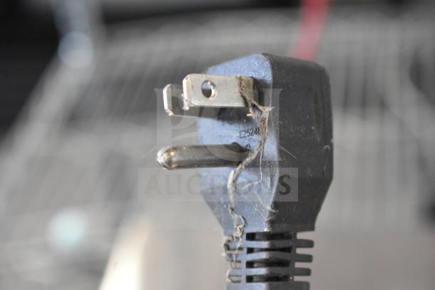 Close-up of a power plug from an Arctic Air AUC27FZ freezer, showing some wear and a dust coating.