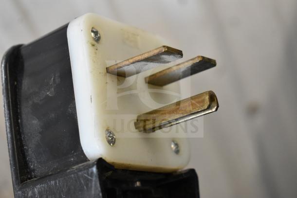 Power plug for Ice-O-Matic ICE1506HT1 ice machine. Three-pronged, metal contacts with white base, attached to a black cord.