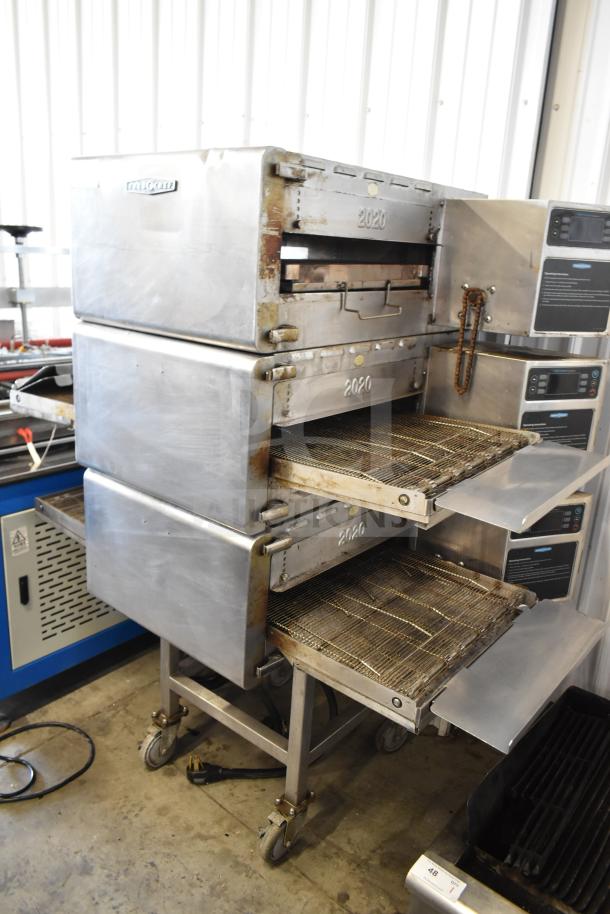 Three Turbochef HhC2020 conveyor ovens on a stand with casters, showing sturdy construction and 2020 markings.