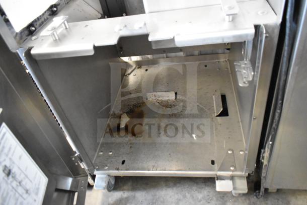 JBT 2ND-GEN-MFJ-HE citrus juicer interior, showing commercial floor style, on casters, minor wear visible.