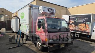 UD International Reefer Box Truck with Thermo King unit, pink cab, exterior signage, appears in used condition, parked outdoors.