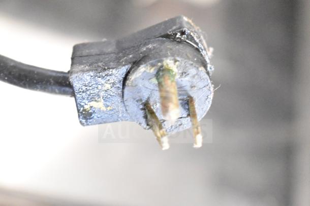 Close-up of electrical plug for 2021 Delfield F2973CP Chef Base. Features a three-prong design, moderate wear visible.
