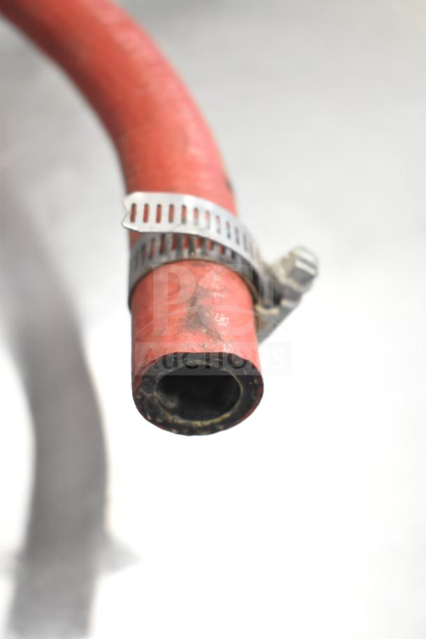 Close-up of a red hose with a metal clamp, part of a Hobart LXLH commercial undercounter dishwasher system.