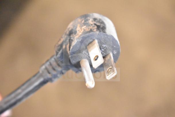 Close-up of a three-pronged electrical plug for the Delfield 406-STAR4 Commercial Undercounter Cooler, showing wear marks.