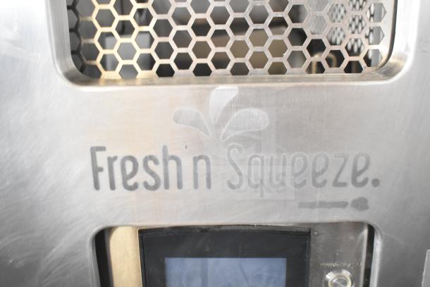 Commercial citrus juicer, JBT 2ND-GEN-MFJ-HE, "Fresh N Squeeze" branding visible, hexagonal grate design, 115V, on casters.