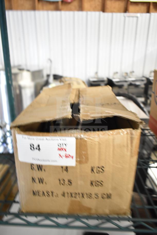 Cardboard box labeled with auction details, containing 50 sharpened stainless steel chef knives.