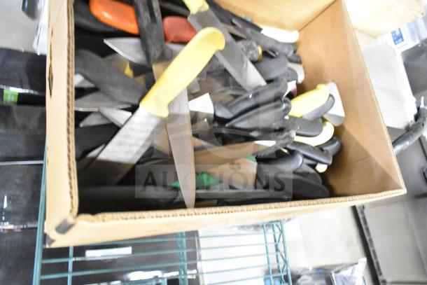 Box of 100 sharpened stainless steel chef knives with various colored handles, ideal for culinary use.