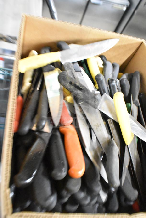 Box of assorted stainless steel chef knives with various colored handles, sharpened, in used condition.