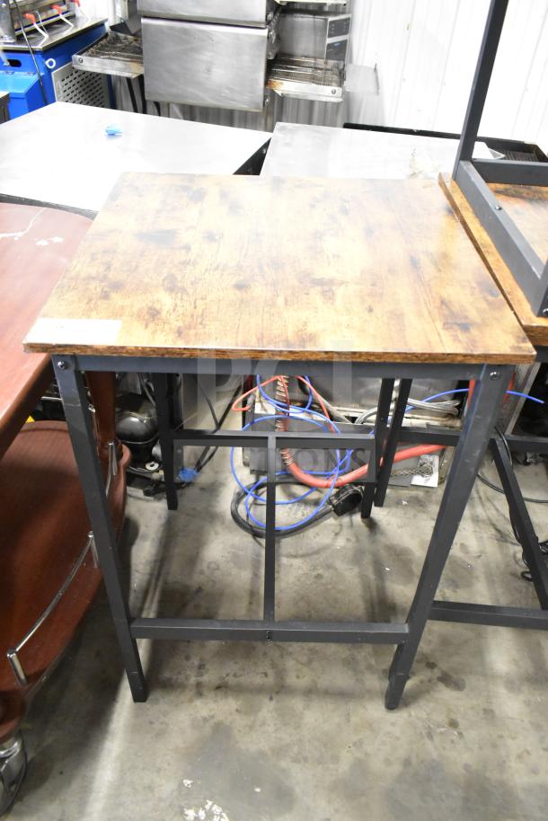 24 wood-pattern tables with black metal frames, including matching bar-height stools. Good condition, industrial style.