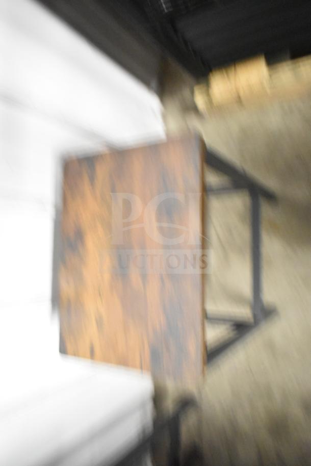 Blurry image of a wood-patterned surface on a black metal frame, part of a furniture set including tables and bar-height stools.