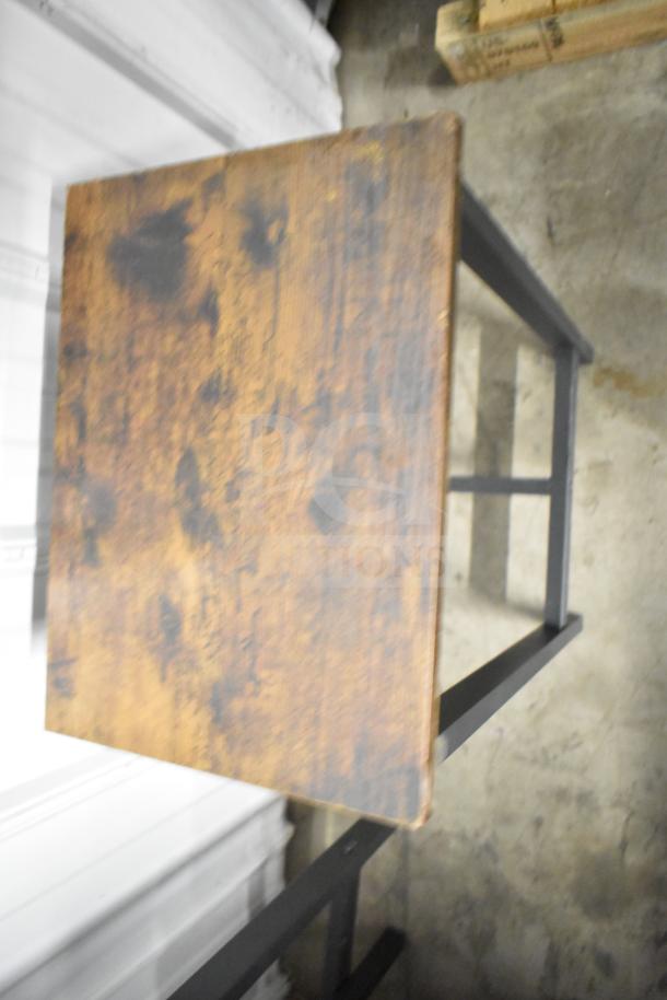 Wood-pattern table with black metal frame. Rustic finish, bar height. Part of a 24-unit set including stools.